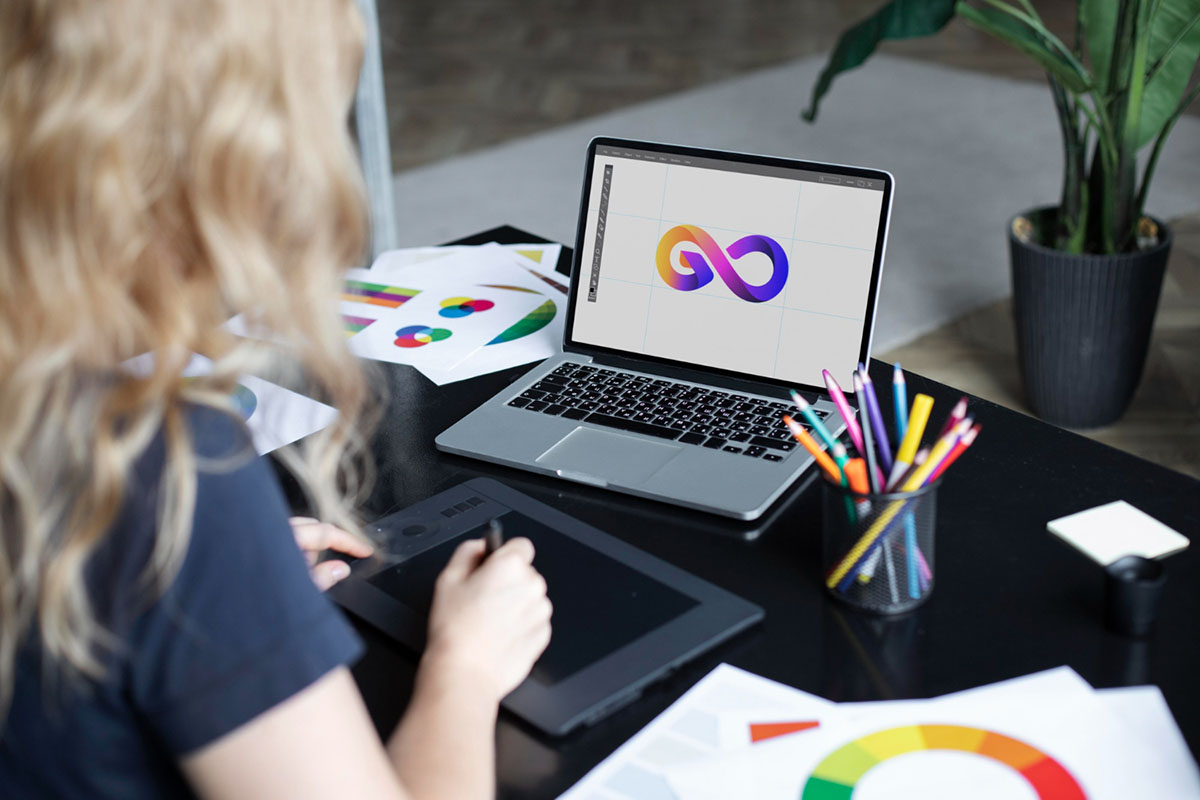 female logo designer working her tablet connected laptop